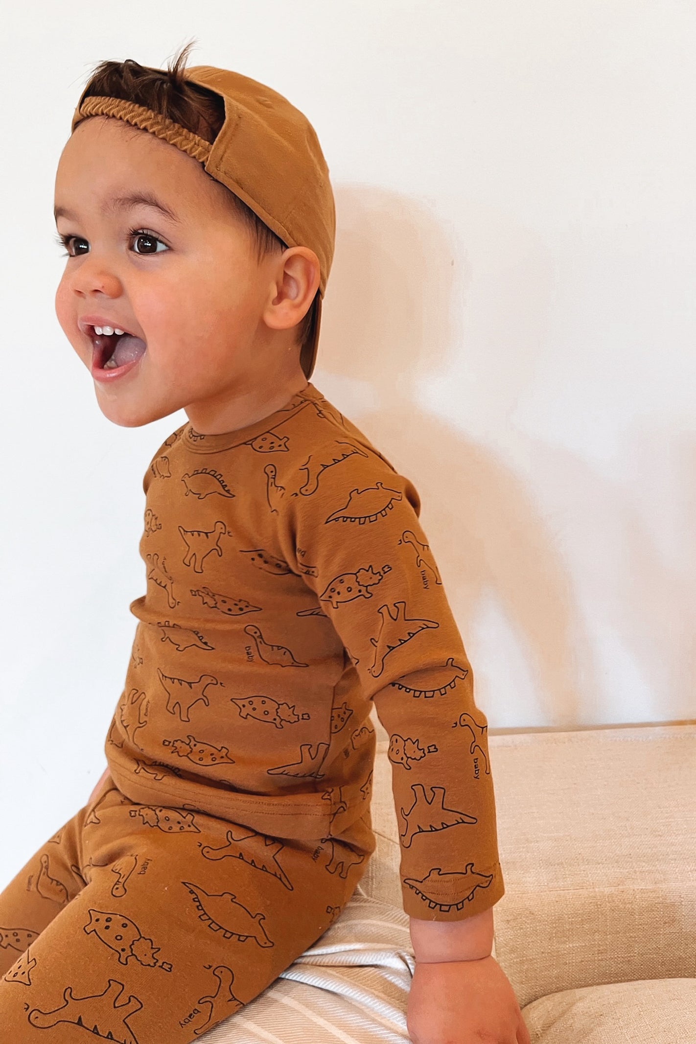 boy wearing brown dinosaur set