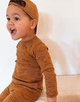 boy wearing brown dinosaur set